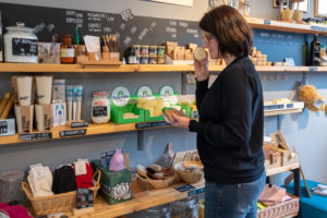 A customer smells a soap in an unpacked shop. A customer smells a soap in an unpacked shop.